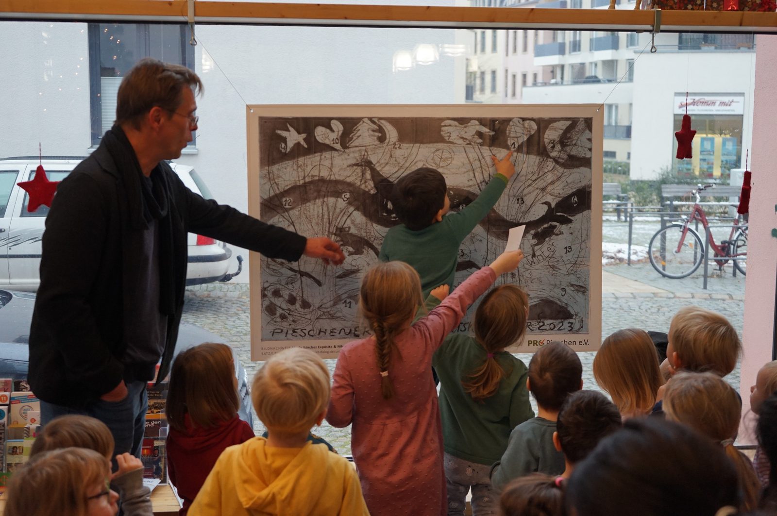 Kinder beim Öffnen des Kalenders 2023 in der Bibliothek